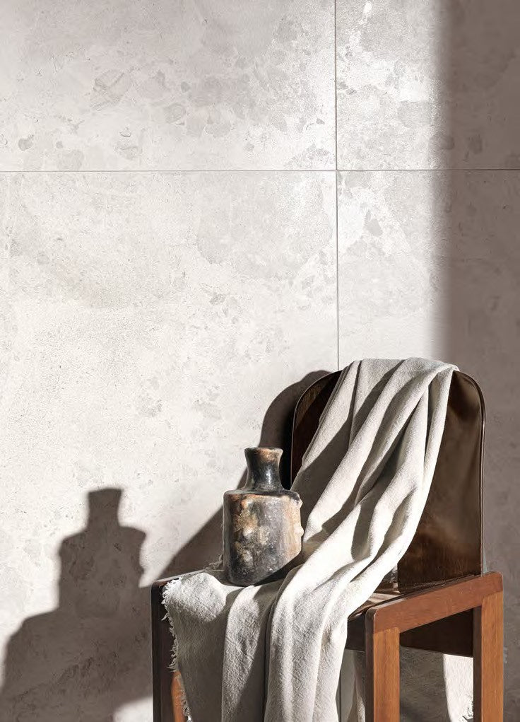 Calypso Shine Porcelain Tile on a wall with a lounge chair